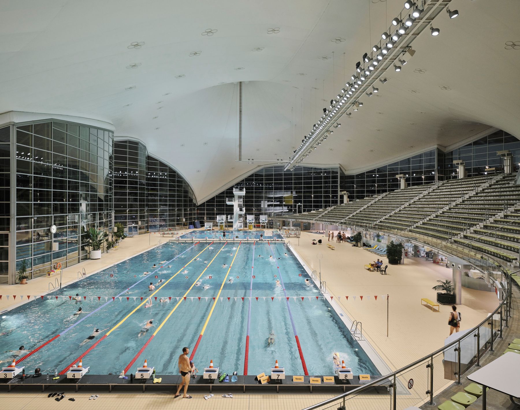 Aquatic Centre at Olympic Park, Munich. Client: Stadtwerke München GmbH. Architecture: Behnisch  & Partner (architect), Otto Frei (roof construction), Stuttgart / Planplus GmbH Architekten, Munich (remodelling, refurbishment, project planning). Electrical engineering: Ingenieurbüro Riemhofer, Munich, Paul and Michael Riemhofer, Munich. Lighting design: 3lpi lichtplaner + beratende ingenieure partnerschaftsgesellschaft mbb, Munich, Beatrice Seidt, Florian Zach. Construction management: ap architektur und projekte gmbh, Munich. Photography: David Schreyer.