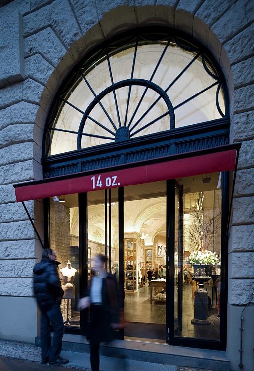 Facade of the 14 oz. store in Berlin, featuring inviting lighting with ERCO Logotec spotlights.