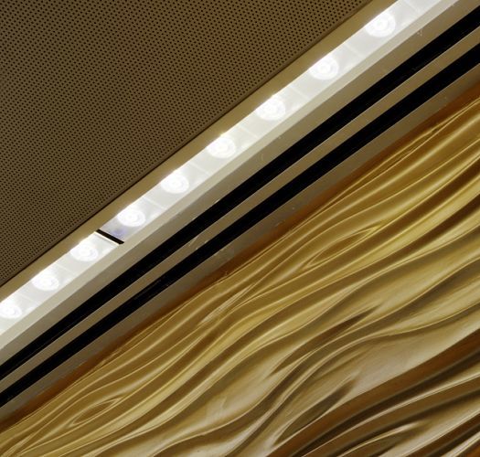 ERCO wallwashers illuminate a gold wall beneath a ceiling, creating a bright and inviting atmosphere.