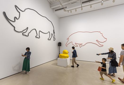 Wallwashing in a museum: Animal artwork and visitors under ERCO lighting.