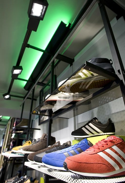 Adidas NEO shoes on display, illuminated by ERCO LED spotlights in Cologne store.
