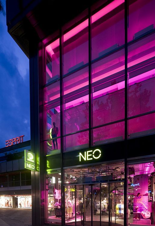 Adidas NEO store in Berlin, dynamically lit with ERCO Optec spotlights and colored accents.