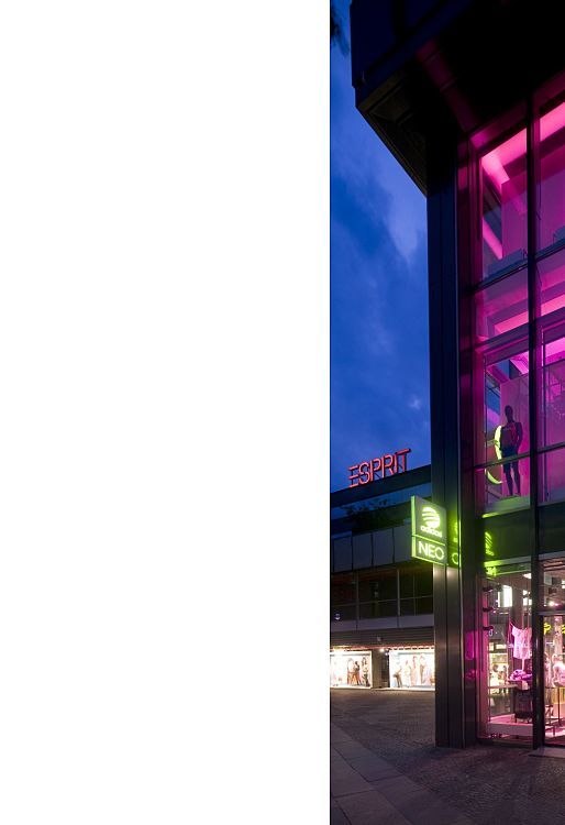 Adidas NEO store in Berlin, dynamically lit with ERCO Optec spotlights and colored accents.
