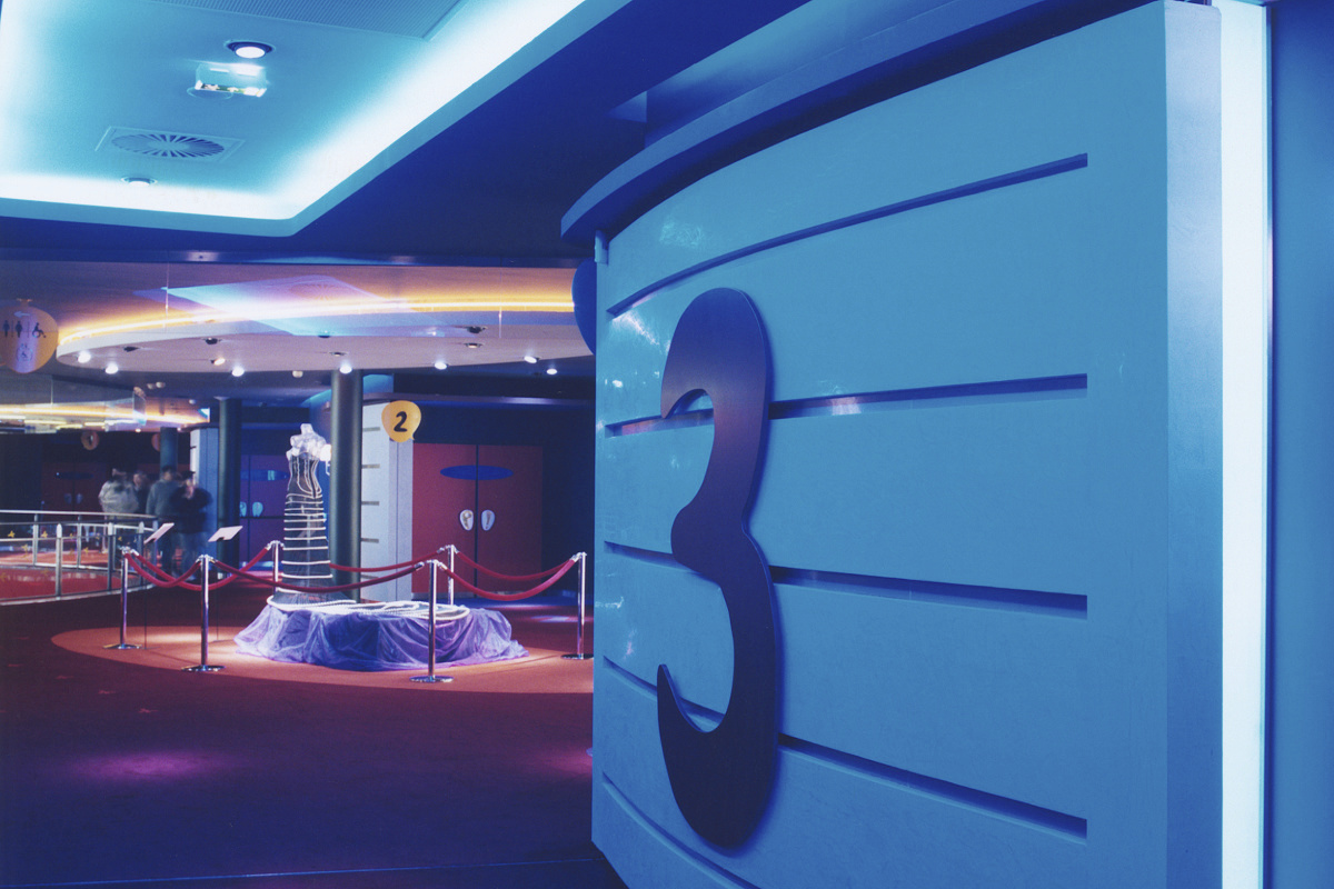 Blue wall design with the number 3 in an exhibition space, influenced by ambient colors.