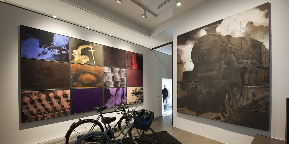 Art gallery in Rome featuring ERCO Light Board spotlights illuminating artworks and bicycles.