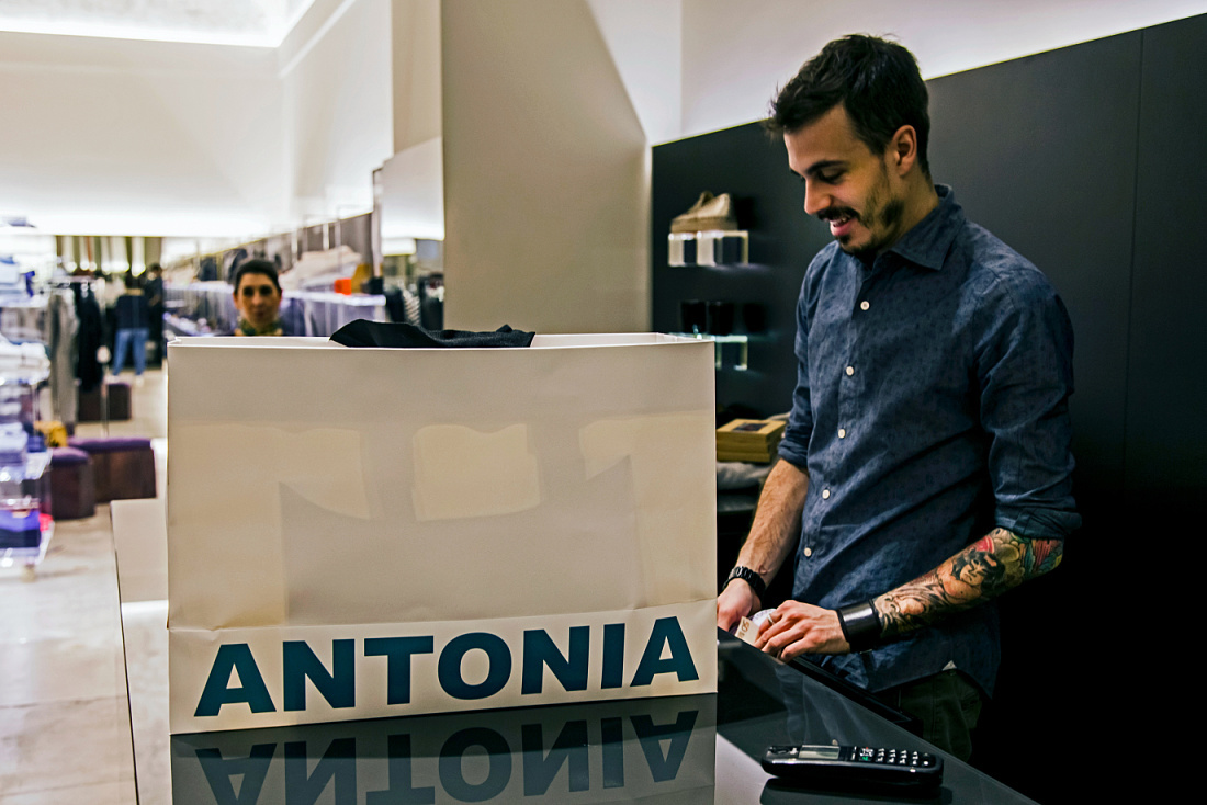 Cashier at Antonia store in Milan, featuring ERCO Optec spotlights for accent lighting.