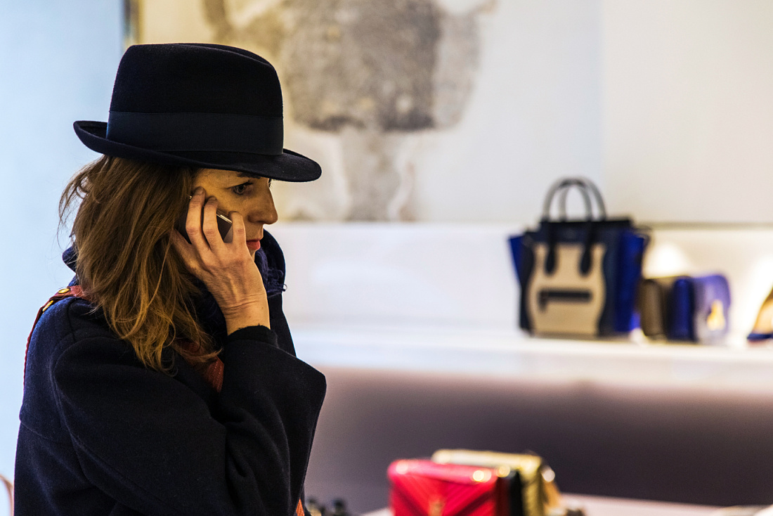 Customer on phone in Antonia store, Milan, lit by ERCO Optec spotlights.