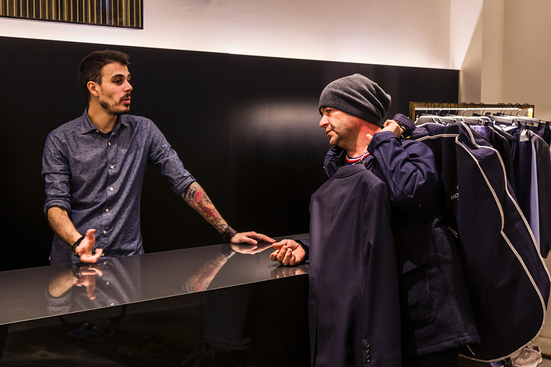 Customer with clothing at Antonia store, Milan, lit by ERCO Optec spotlights.