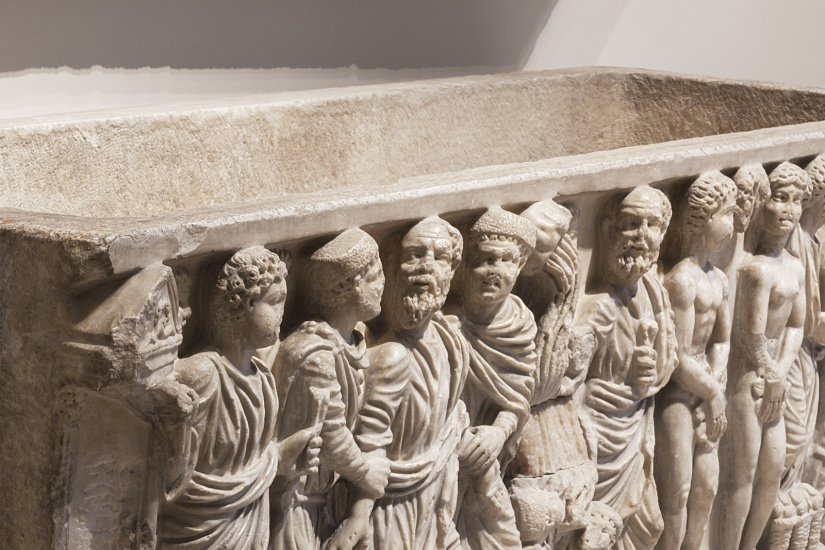 Ancient sarcophagus with figure frieze in Madrid's Archaeological Museum, illuminated by ERCO LED lighting.