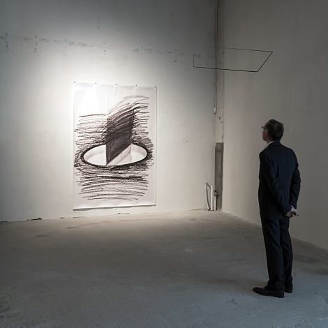 Man viewing a drawing at Axel Vervoordt Gallery, illuminated by ERCO LED spotlights.