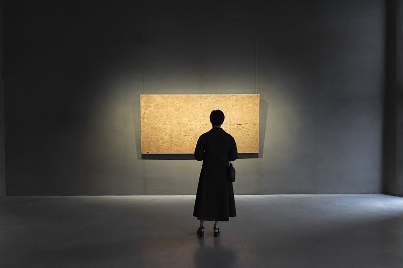 Gallery visitor views artwork illuminated by ERCO LED spotlights at Axel Vervoordt Gallery.