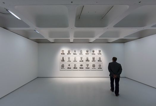 Man viewing art at the Barbican Gallery, illuminated by ERCO LED lighting.