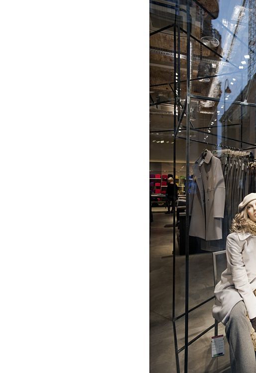 Benetton store window display featuring mannequins lit by ERCO LED lighting.