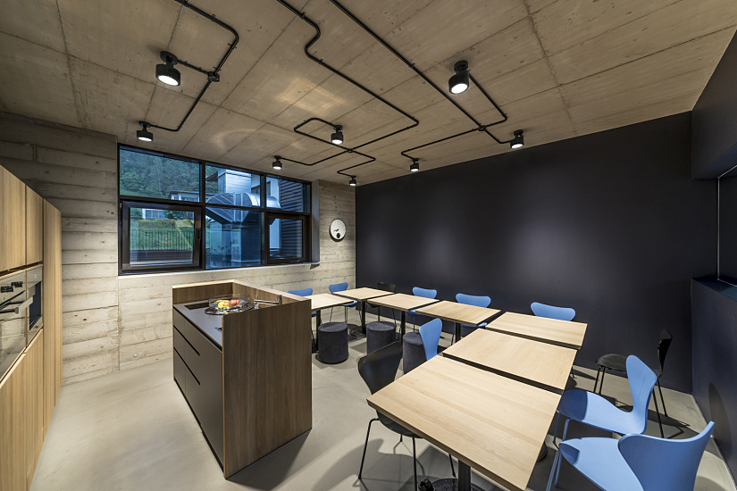 Bernd Gruber Manufactory interior featuring ERCO Parscan spotlights accenting natural materials and black contrasts in the design.