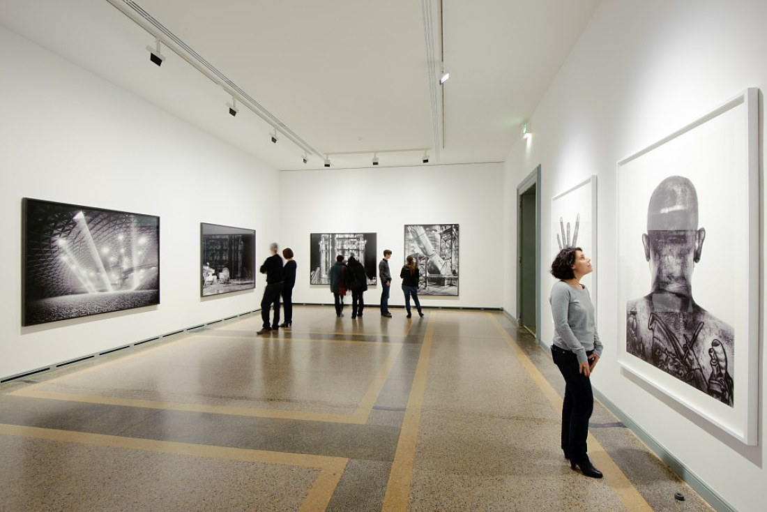 Visitors view the Industrious exhibition at the Berne Art Museum, illuminated by ERCO Light Board LED spotlights.