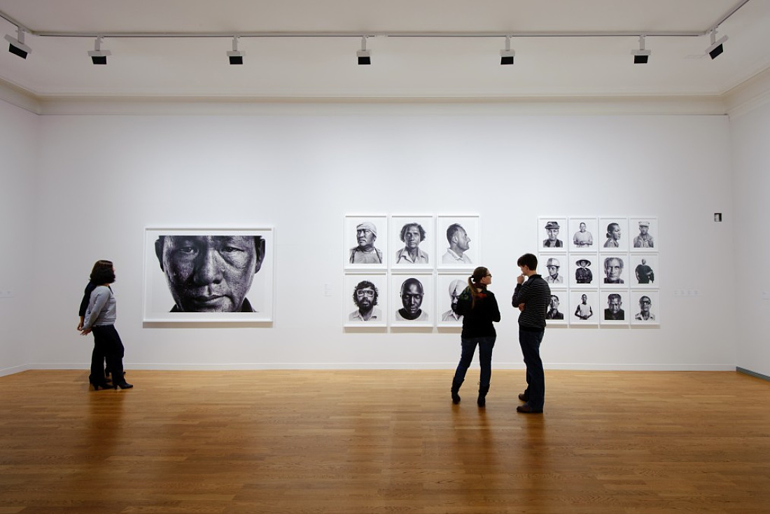 Visitors view portraits at the Berne Art Museum, illuminated by ERCO Light Board LED spotlights.