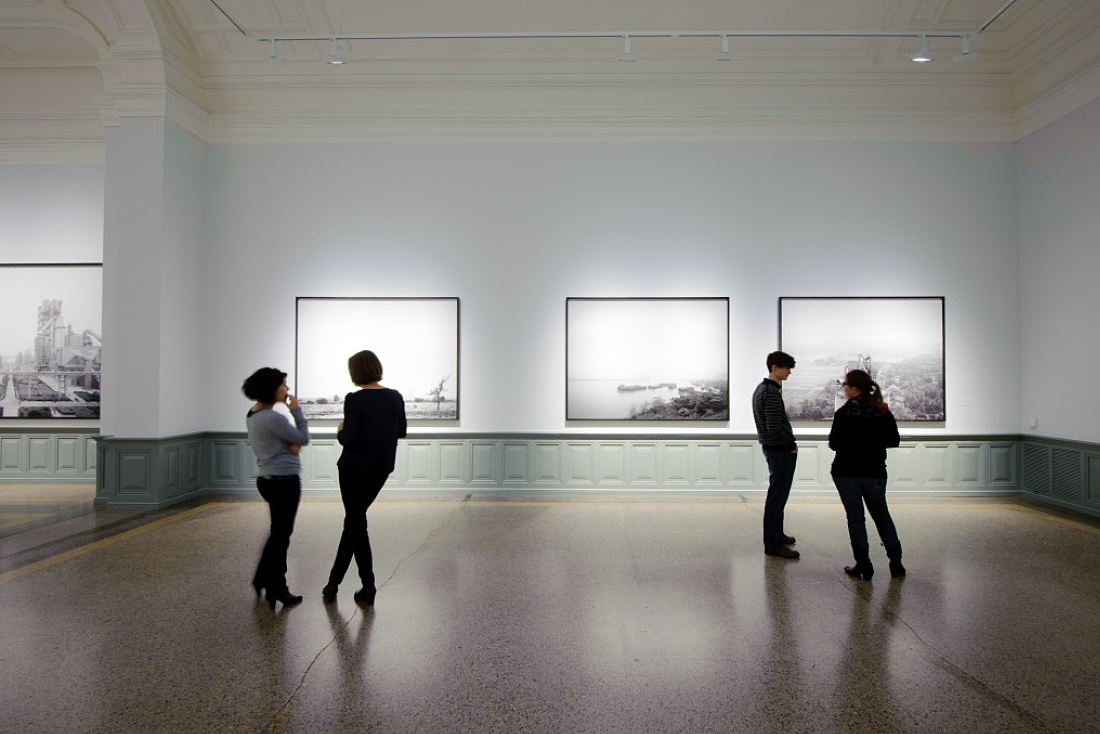Visitors view Holcim photographs illuminated by ERCO Light Board LED spotlights at the Berne Art Museum.