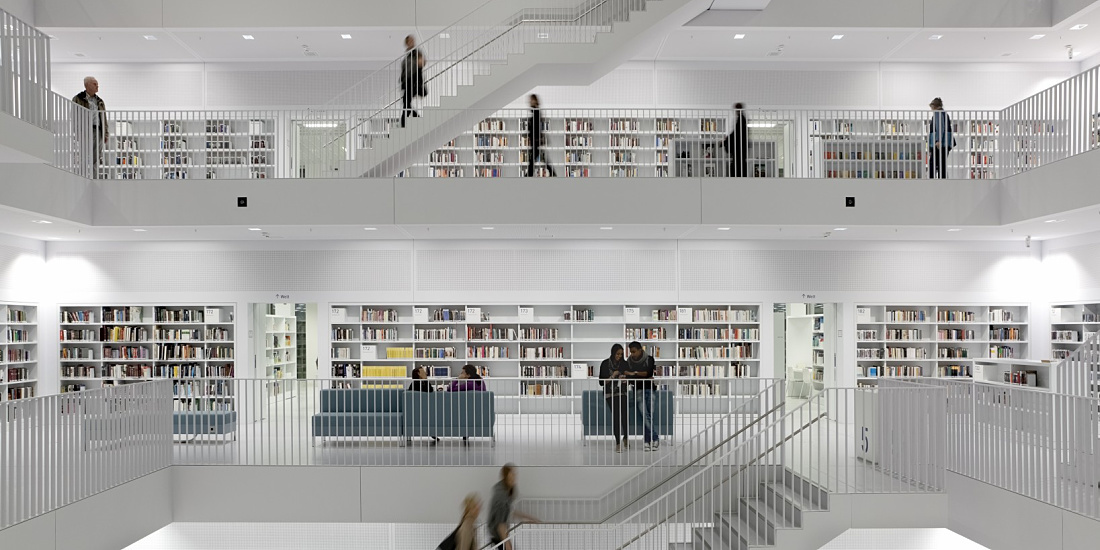 Bibliothek 21 in Stuttgart: Bright, modern architecture with bookshelves and staircases, illuminated by ERCO lighting.
