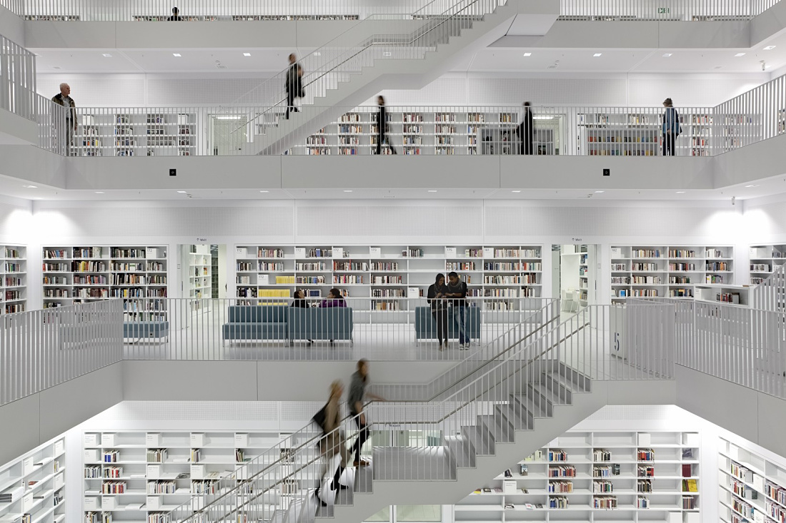 Bibliothek 21 in Stuttgart: Bright, modern architecture featuring bookshelves and staircases, illuminated by ERCO lighting.