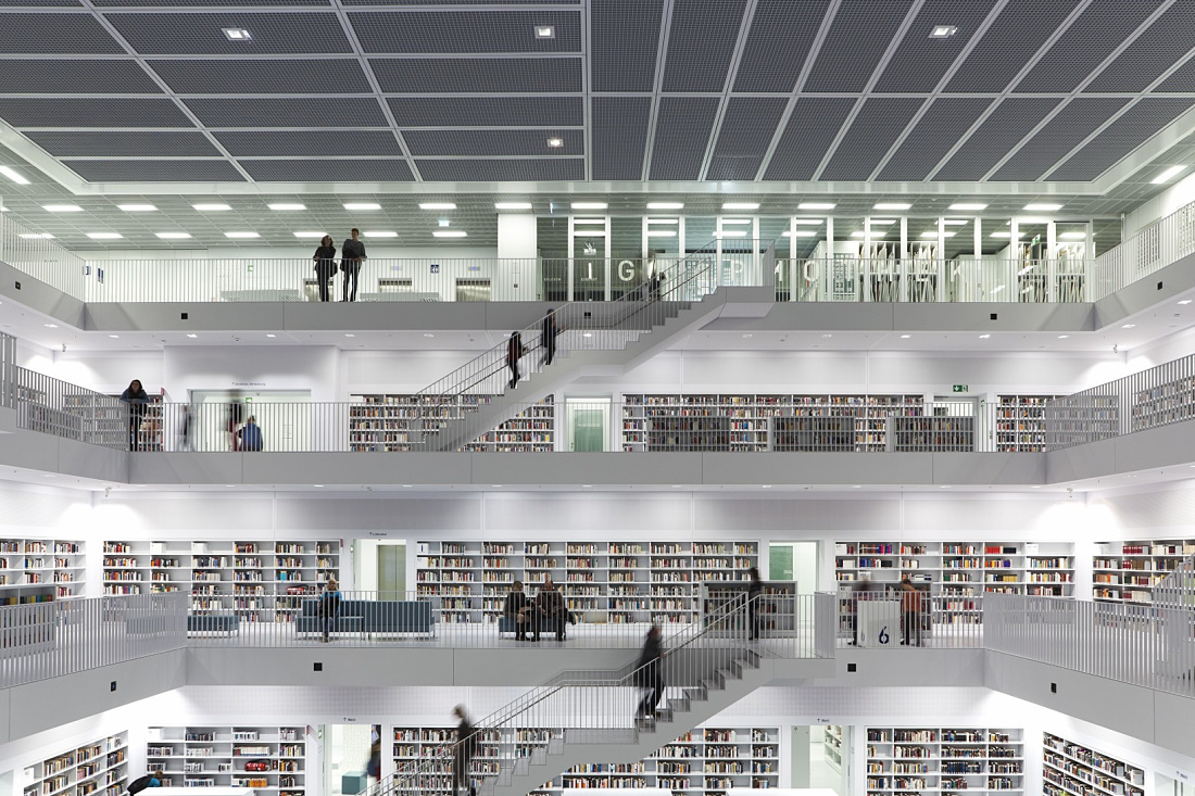 Bibliothek 21 in Stuttgart: Multistory hall with bookshelves and stairs, illuminated by ERCO lighting.