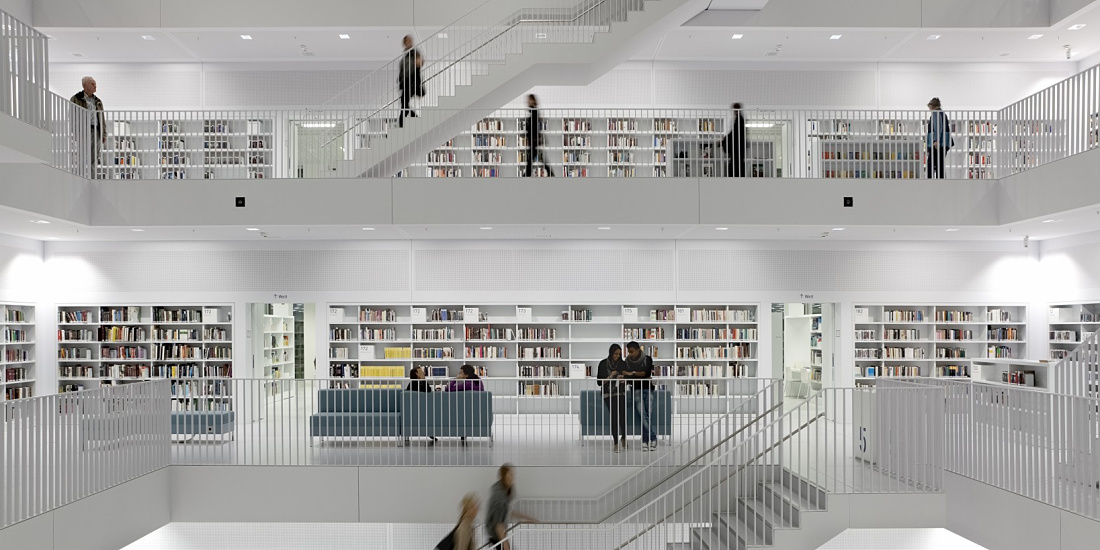 Bibliothek 21 in Stuttgart: Bright, modern architecture with bookshelves and staircases, illuminated by ERCO lighting.