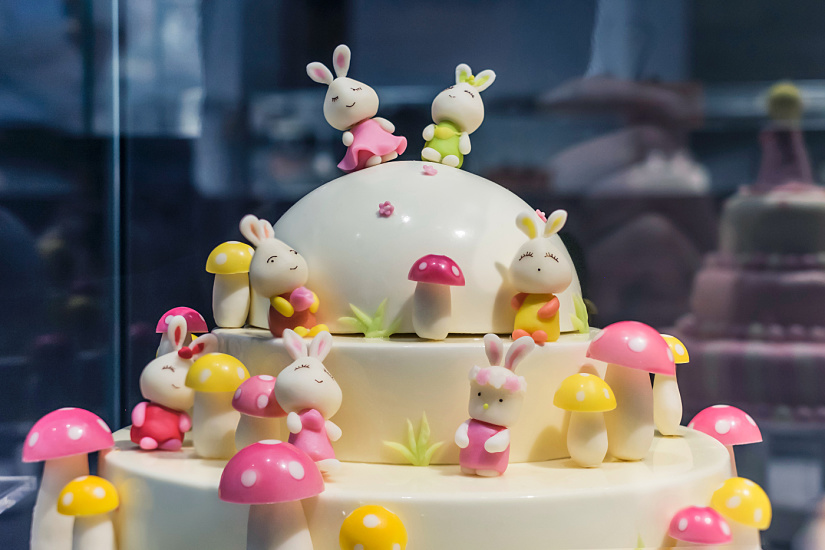 Decorative cake with bunny figures and mushrooms, illuminated by ERCO Optec spotlights at Black Swan patisserie, Beijing.