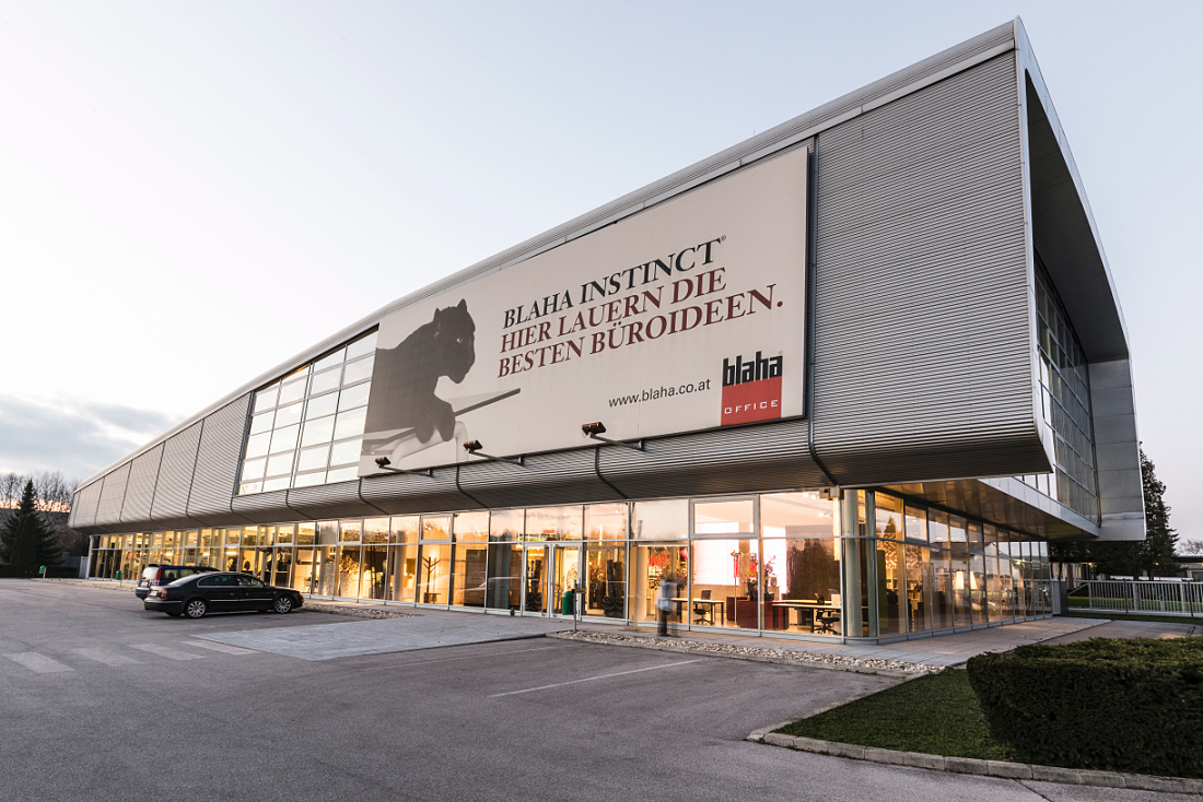Blaha Office showroom in Korneuburg, illuminated by ERCO LED lighting, showcasing office furniture and acoustic systems.
