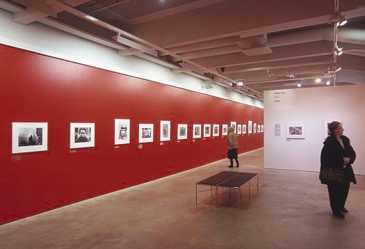Exhibition with red wall color influencing the body color of the artworks.
