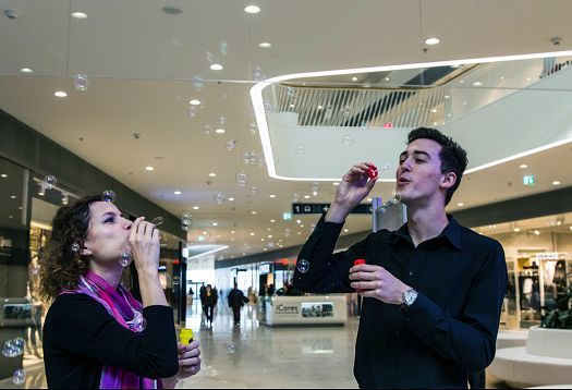 People blowing bubbles under ERCO Skim downlights at Bory Mall, Bratislava.