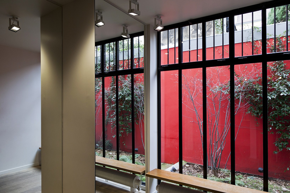 ERCO LED spotlights illuminate a Paris boutique with a view of a green courtyard.