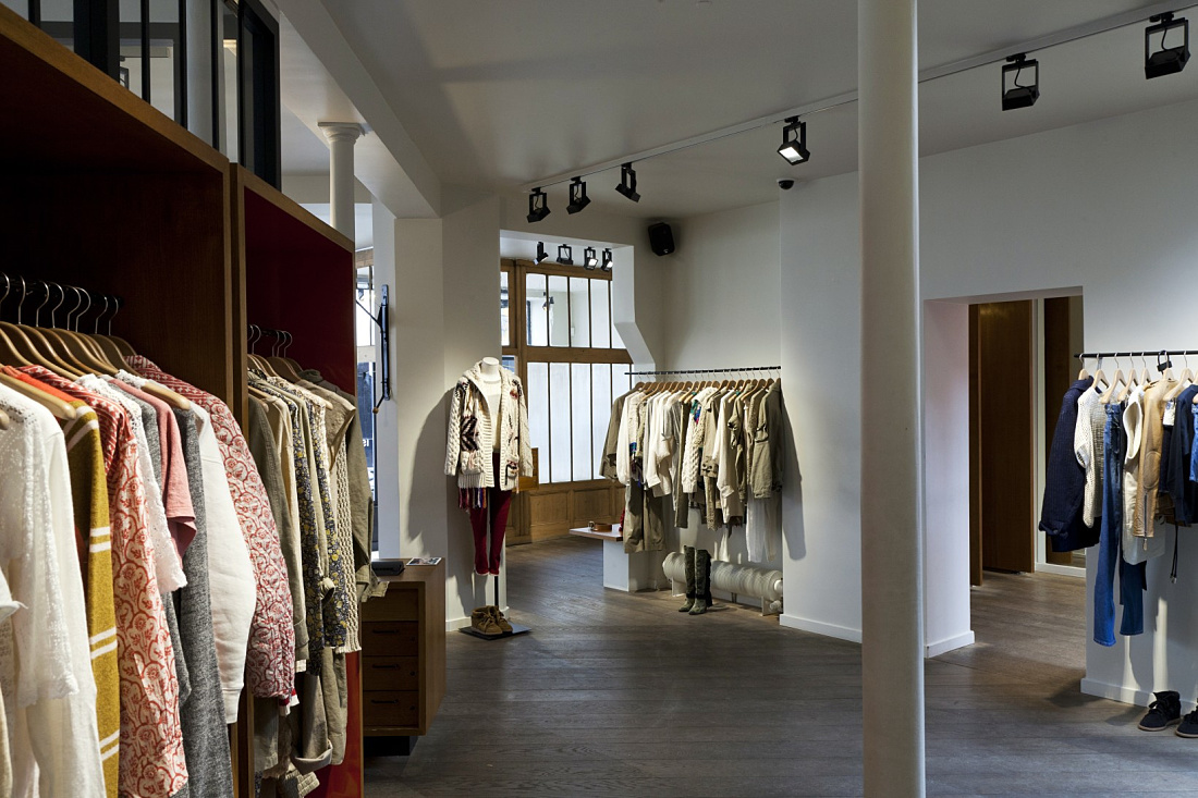 Interior of a Paris fashion boutique featuring ERCO LED spotlights for dynamic clothing display.