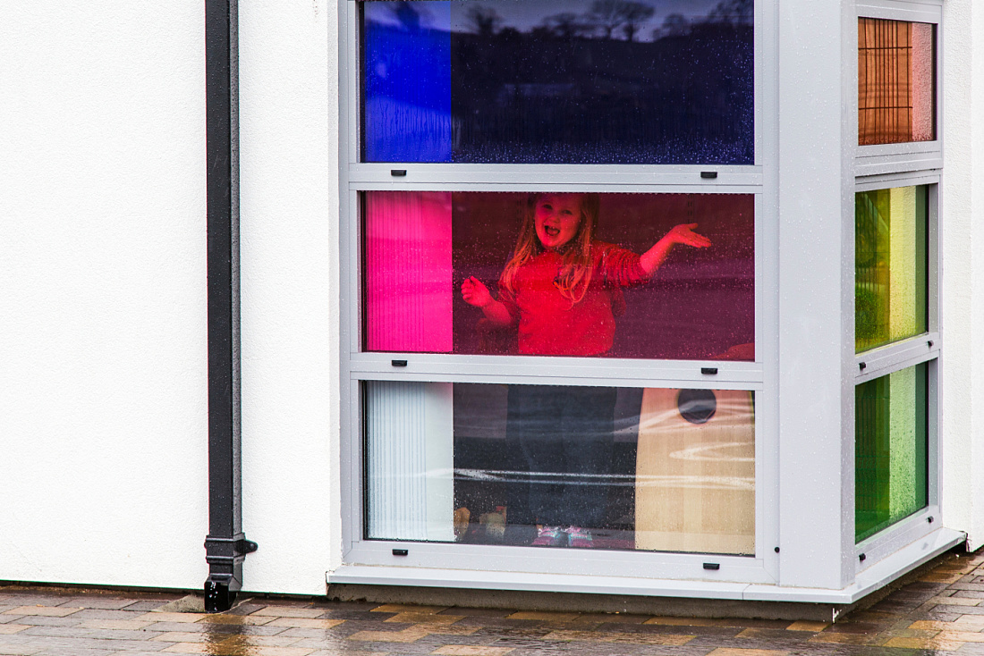 Child in window of Brontë Nursery, Rathfriland, with colored ERCO LED lighting.