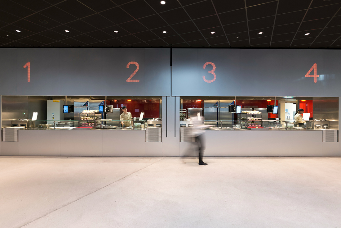 Cafeteria at Vienna University of Economics, featuring LED lighting and food service counters.
