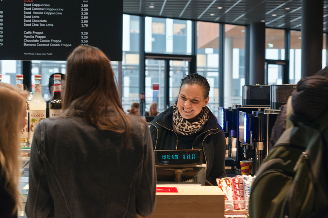 Smiling cashier at the Vienna University of Economics and Business cafeteria.