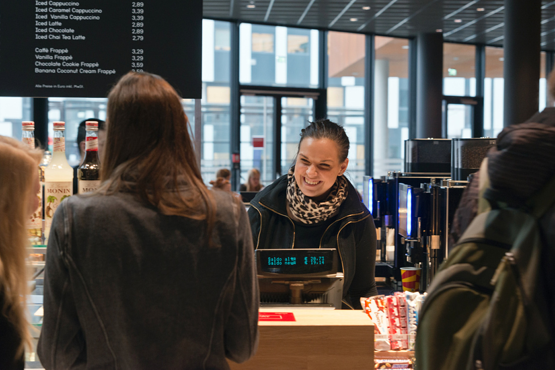 Smiling cashier at the Vienna University of Economics and Business cafeteria.