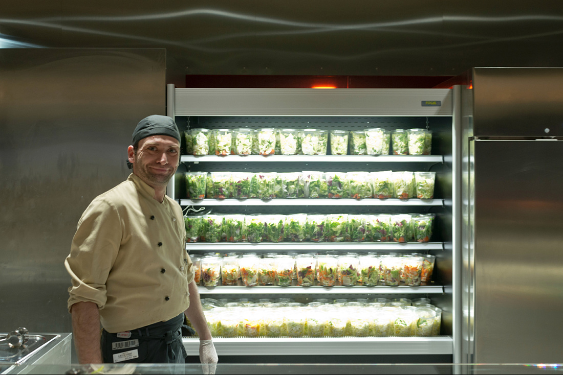Chef in front of a salad display at the Vienna University of Economics cafeteria.