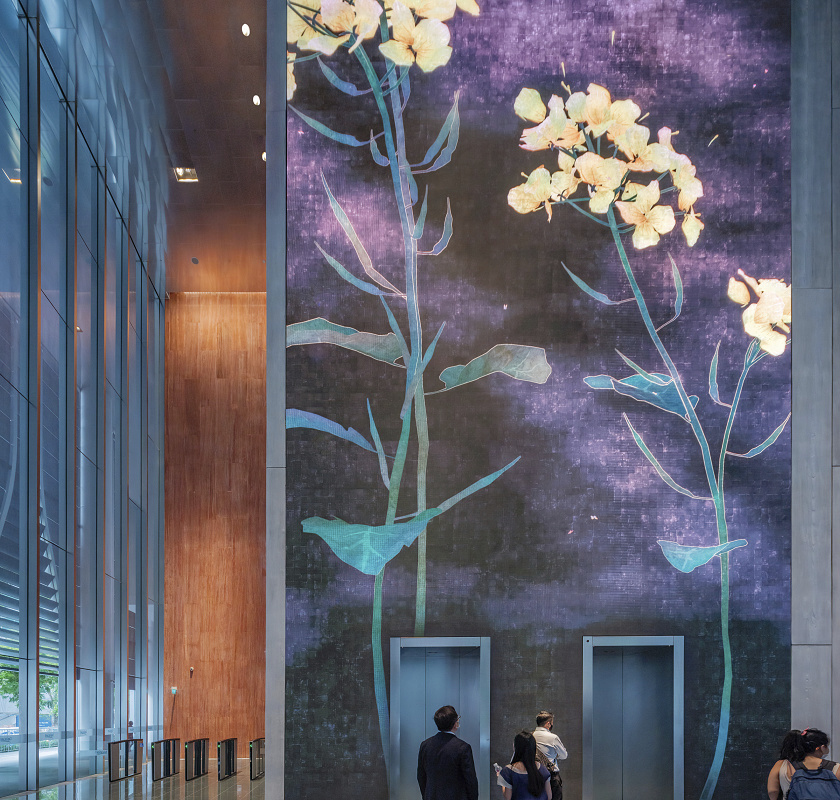 CapitaSpring lobby in Singapore featuring ERCO lighting and a floral wall.