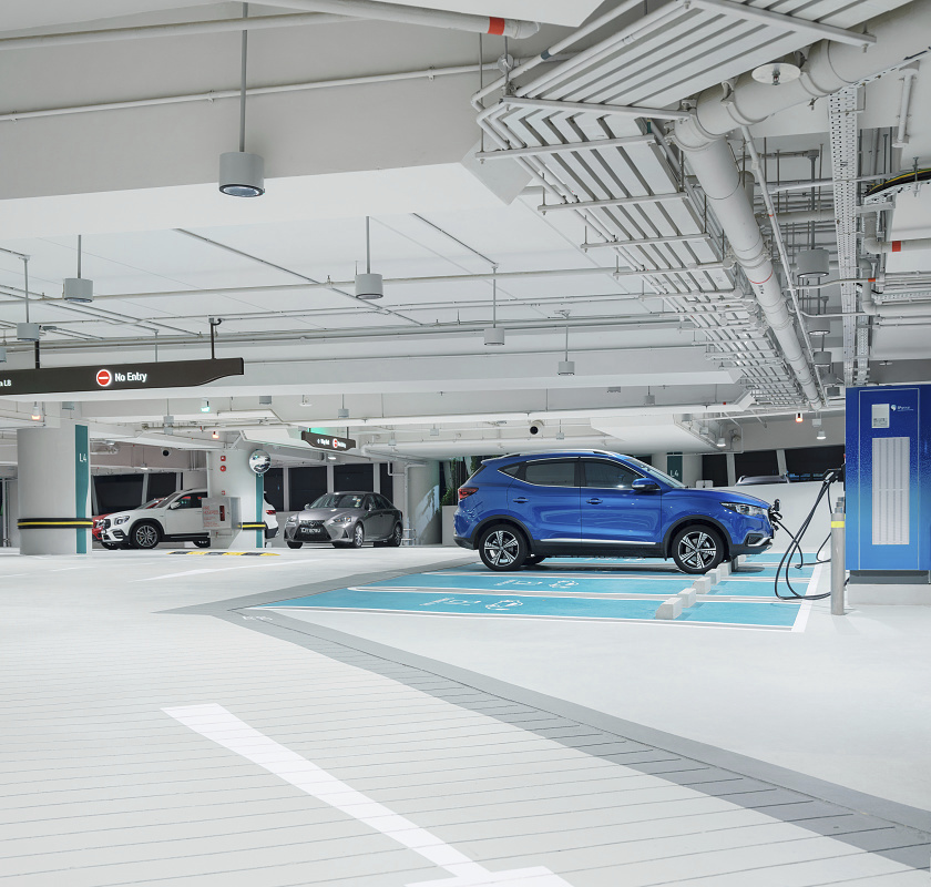 CapitaSpring car park in Singapore with ERCO Skim downlights, featuring an electric car charging, ensuring visual comfort and safety.
