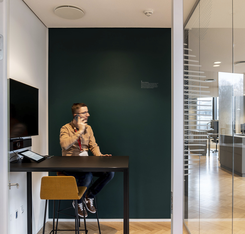 Man on phone at Carlsberg HQ, illuminated by ERCO Skim and Quintessence recessed luminaires.