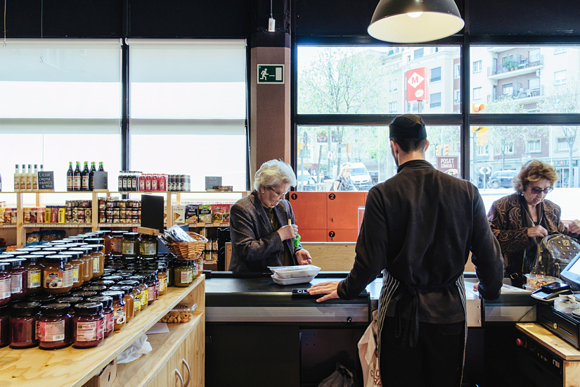 Customers at the Casa Tió checkout, illuminated by ERCO LED spotlights for optimal color rendering.