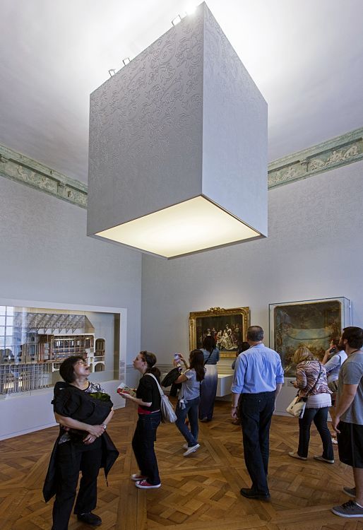 Visitors view Logotec LED spotlights in Château de Versailles exhibition halls, accentuating exhibits with ambient lighting.