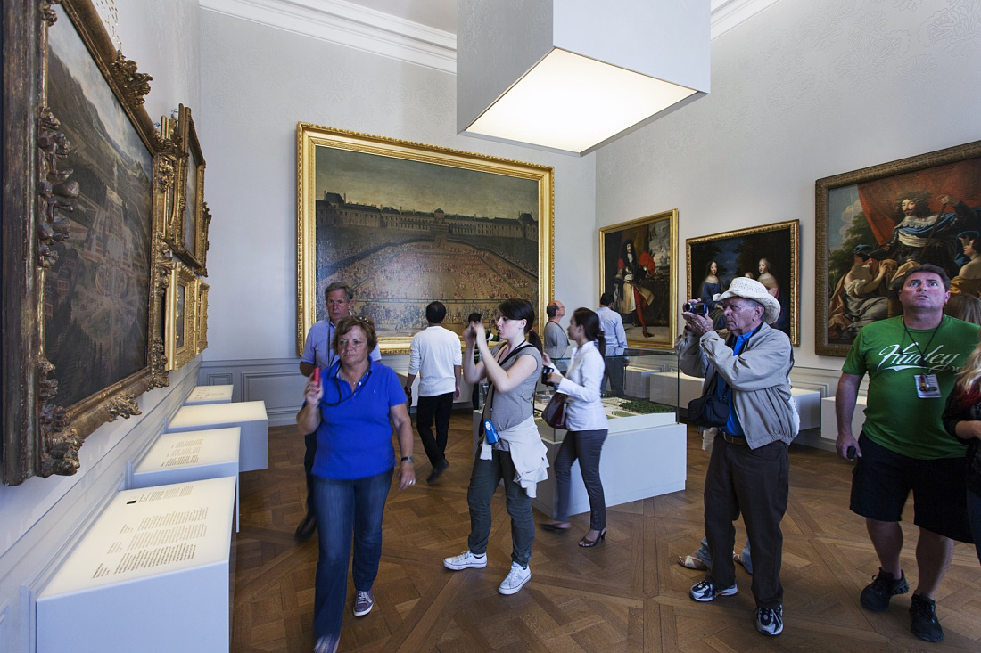 Visitors view art in Château de Versailles exhibition halls, lit by ERCO Logotec LED spotlights.
