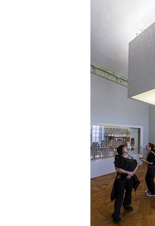 Visitors view Logotec LED spotlights in Château de Versailles exhibition halls, accentuating exhibits with ambient lighting.