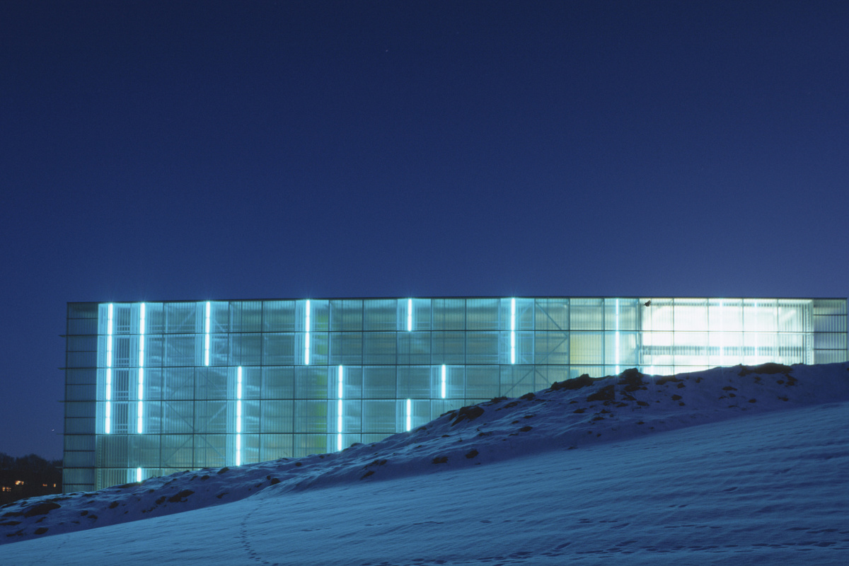 ERCO building with colored light design at night, highlighting architectural features.