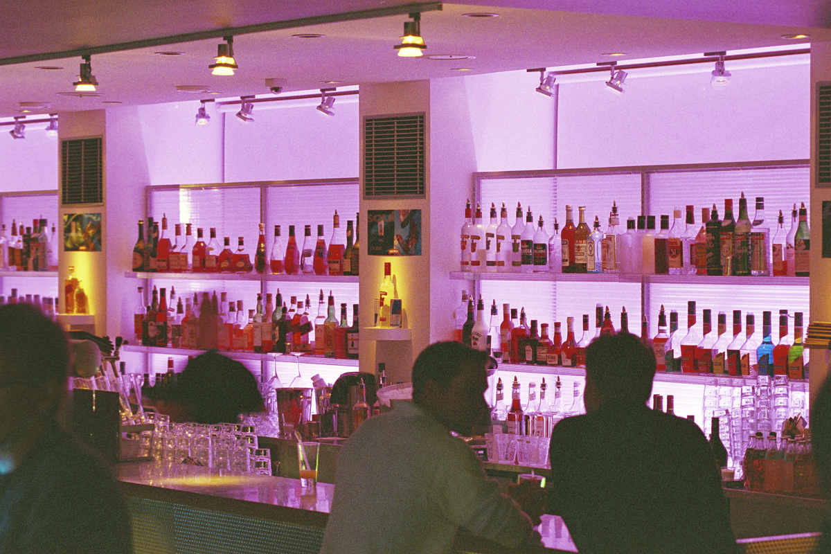 Bar with colored light design: Liquor shelves illuminated for an atmospheric ambiance.