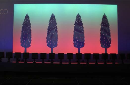Stage design with colorfully lit trees for ERCO lighting design.