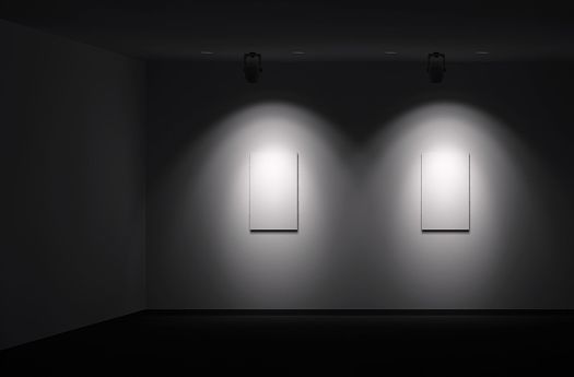 Illuminated artworks demonstrate brightness contrast in a gallery, highlighting visual perception.