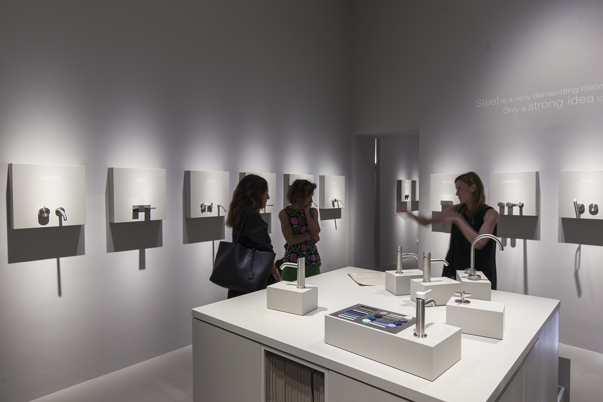 Faucet exhibit showcasing various designs mounted on a wall, demonstrating contrast in lighting design.