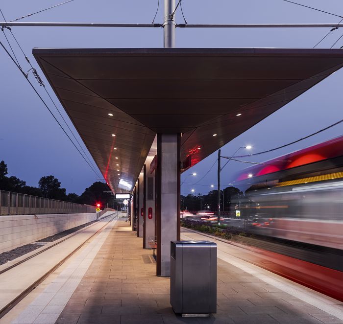 Illuminated train platform with passing train, ERCO LED lighting ensures safety and orientation.