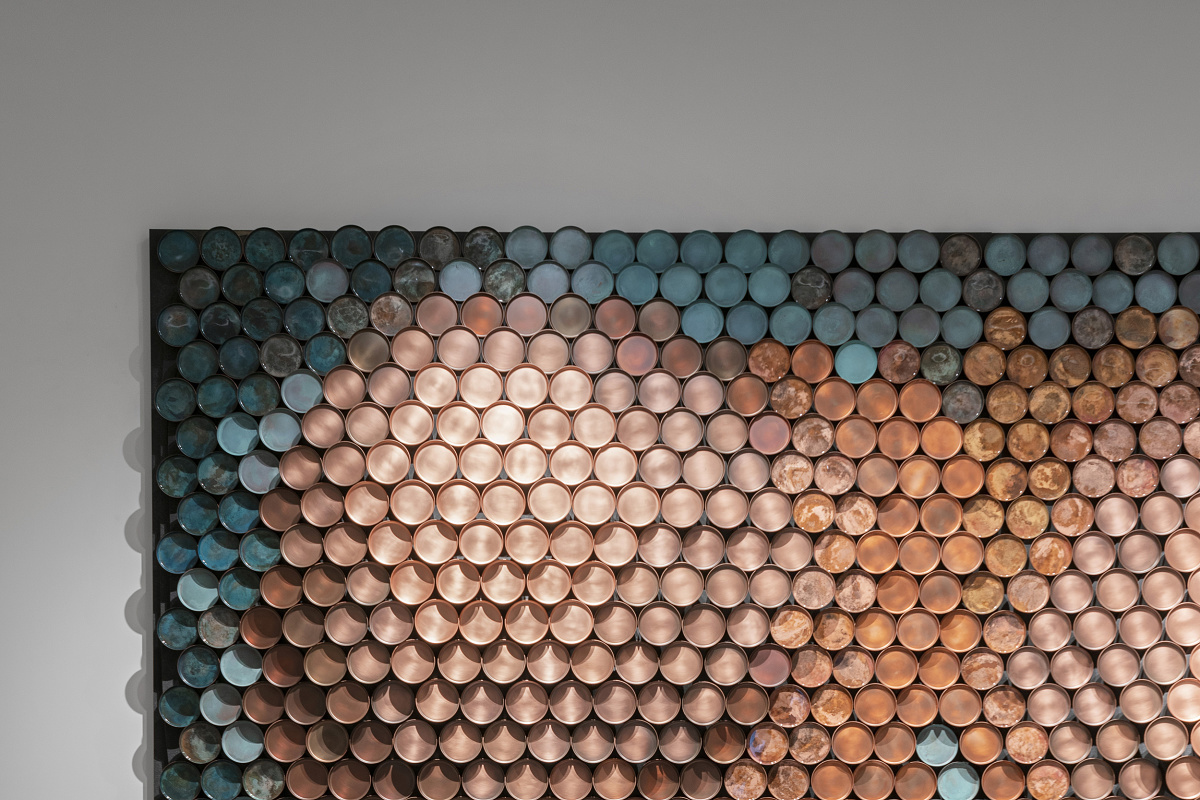 De Castelli metal artwork illuminated by ERCO lighting for accentuation in showroom.